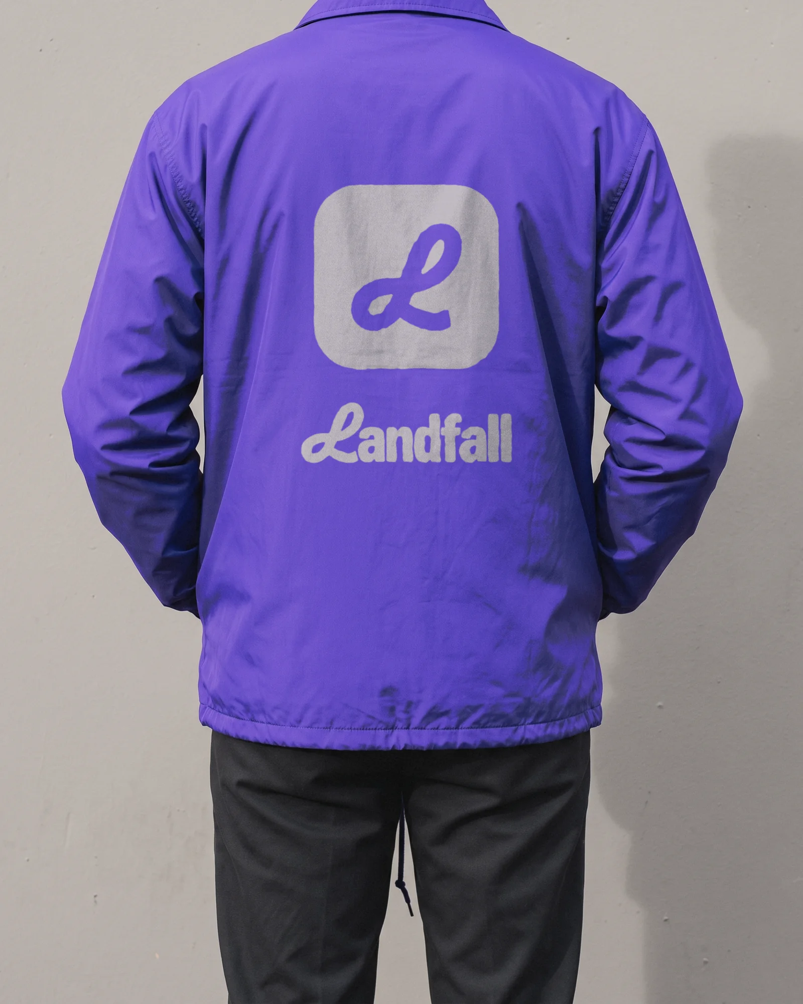 A violet coach jacket with the Landfall badge on the back